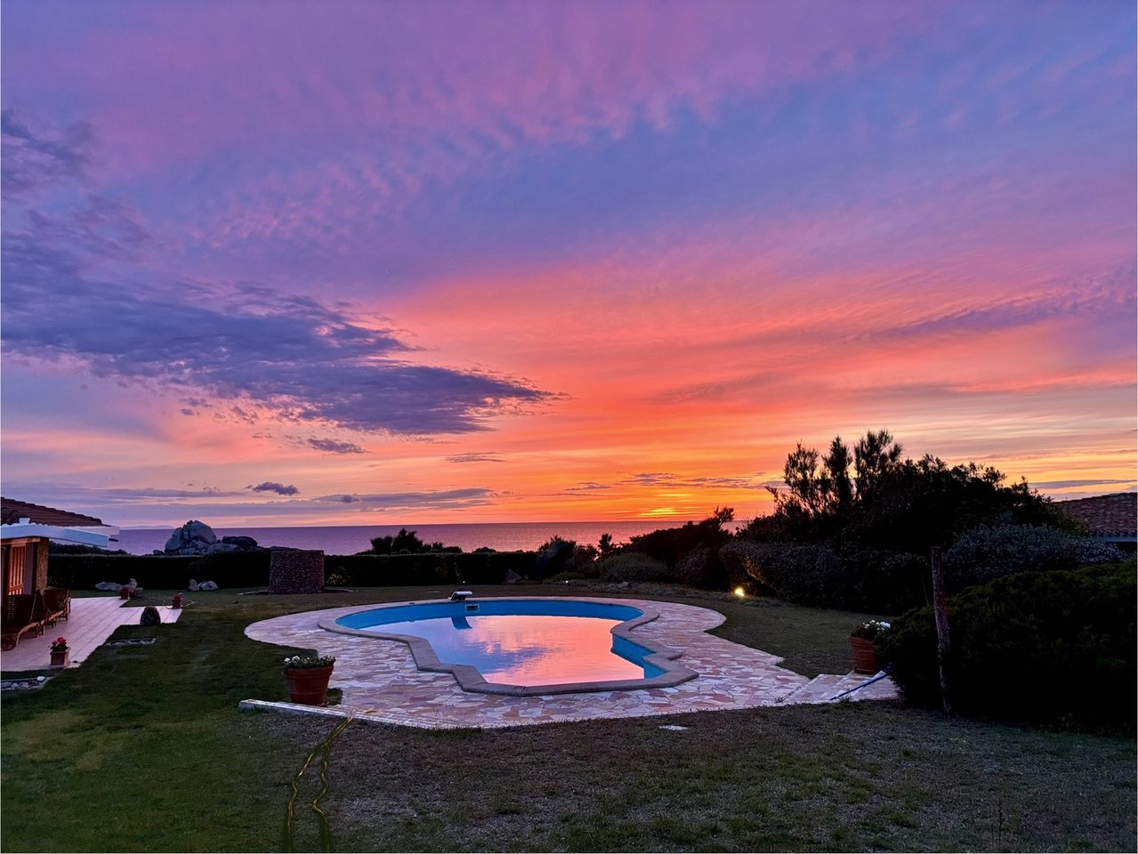 Pool at sunset with dramatic sky over Sardinia